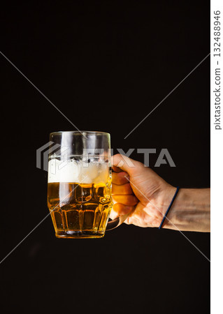 Male hand holding mug of beer 132488946