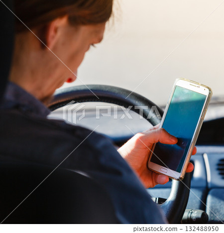 Man using his phone while driving car. Man using his phone while driving car. 132488950