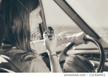 Young man driving car using cb radio Young man driving car using cb radio 132488952