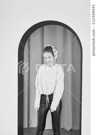 black and white portrait of a teenage girl in front of an arch 132489045