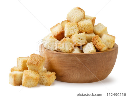 Bread croutons in a wooden plate and a pile on a white background. Isolated Bread croutons in a wooden plate and a pile on a white background. Isolated 132490236
