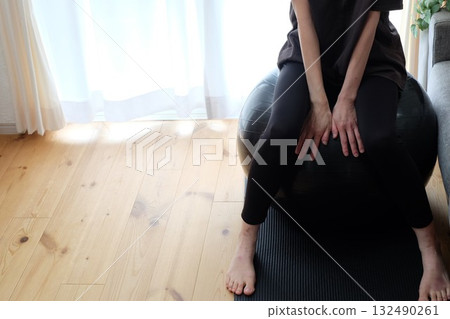 A woman in her 40s sitting on a balance ball 132490261