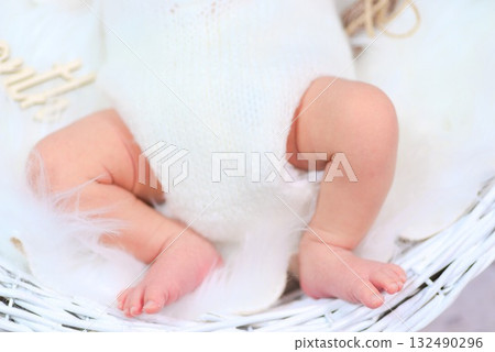 The warmth of life conveyed by the feet of a newborn baby wrapped in soft white 132490296