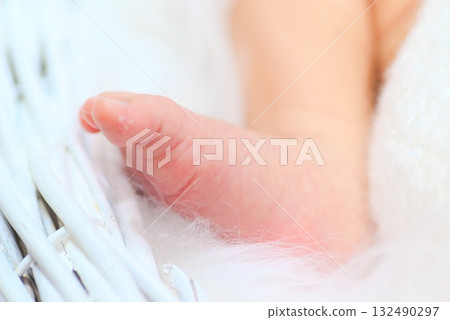 裹著柔軟白色毯子的新生嬰兒的腳傳達著生命的溫暖 裹著柔軟白色毯子的新生嬰兒的腳傳達著生命的溫暖 132490297