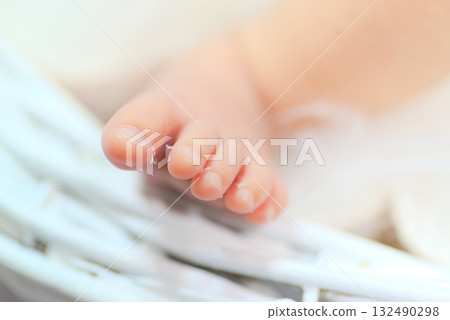 The warmth of life conveyed by the feet of a newborn baby wrapped in soft white 132490298