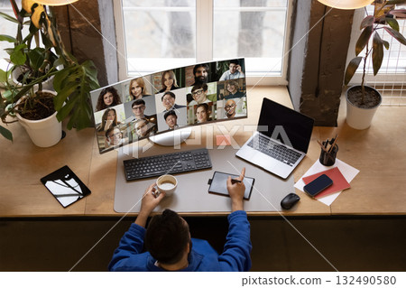 Trendy composition. Manager leading remote meeting with global colleagues on widescreen monitor Trendy composition. Manager leading remote meeting with global colleagues on widescreen monitor 132490580