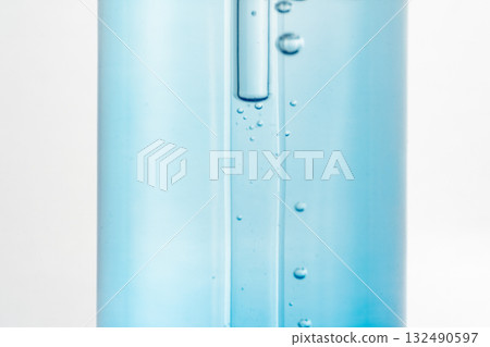Blue glass bottle with a dropper containing air bubbles. Concept of cosmetic serum, skincare, transparency, minimalism, texture, product detail, laboratory-style beauty photography. Blue glass bottle with a dropper containing air bubbles. Concept of cosmetic serum, skincare, transparency, minimalism, texture, product detail, laboratory-style beauty photography. 132490597