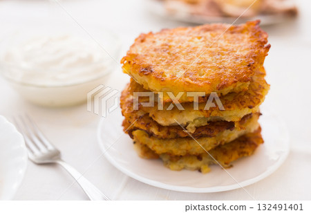 Potato pancakes with sour cream on white plate 132491401