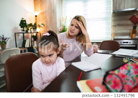 Conflict between parent and child during home study time in cozy kitchen Conflict between parent and child during home study time in cozy kitchen 132491796