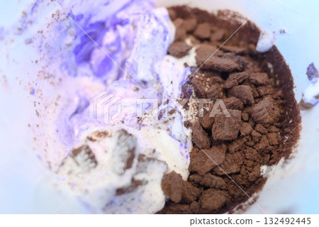 A sweet treat made by mixing chocolate cookies and blueberry ice cream A sweet treat made by mixing chocolate cookies and blueberry ice cream 132492445