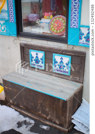 A colorful storefront with wooden benches decorated with Turkish patterns 132492486