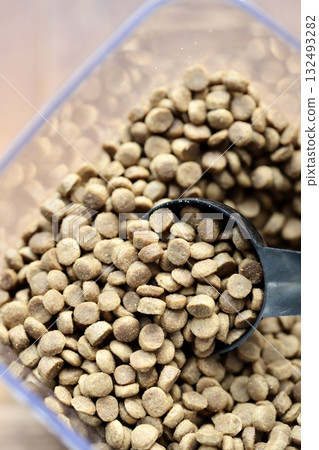 Grain-free small-kibble dry dog food in a clear plastic container 132493282