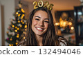 Smiling young woman . Christmas tree with lights in the background. Celebrating New Years Eve. 132494046