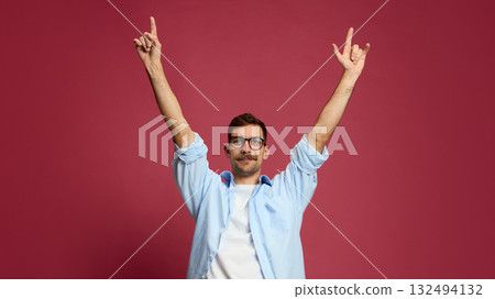 Confident man raising both arms up showing celebration and success emotion 132494132