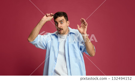 Astonished man lifting glasses with shocked expression and open mouth Astonished man lifting glasses with shocked expression and open mouth 132494152