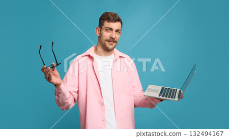 Confused man holding laptop and glasses expressing doubt and hesitation Confused man holding laptop and glasses expressing doubt and hesitation 132494167