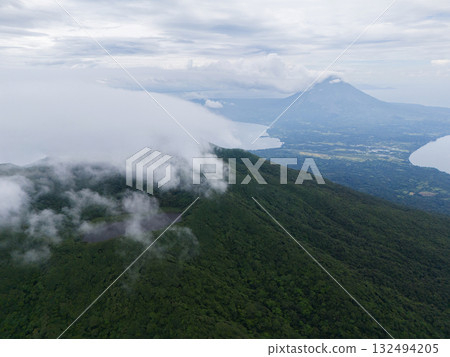 Panoramic view of lush mountains and tranquil lake under cloudy skies in El Salvador Panoramic view of lush mountains and tranquil lake under cloudy skies in El Salvador 132494205