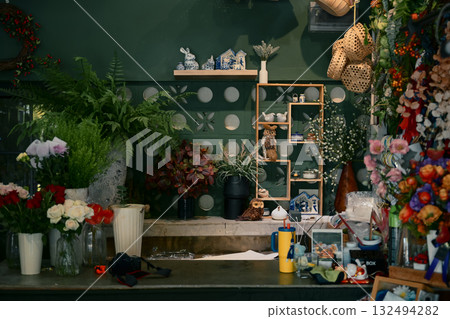 Cozy flower shop interior filled with plants, floral materials, and decorative crafts, creating a warm creative workspace Cozy flower shop interior filled with plants, floral materials, and decorative crafts, creating a warm creative workspace 132494282