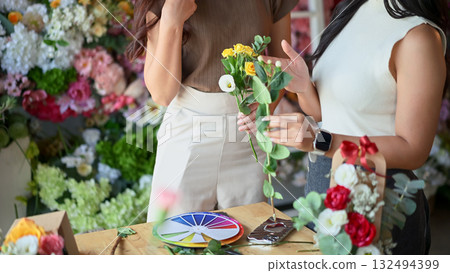 Closeup people learning to arrange flowers in a creative workshop, crafting colorful bouquets with teamwork 132494399