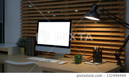 Computer on desk in peaceful nighttime workspace with office supplies Computer on desk in peaceful nighttime workspace with office supplies 132494494