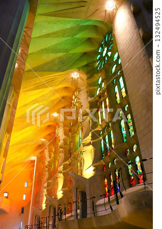 The light shining through the stained glass windows and the mysterious colorful light projected onto the walls inside the Sagrada Familia 132494525