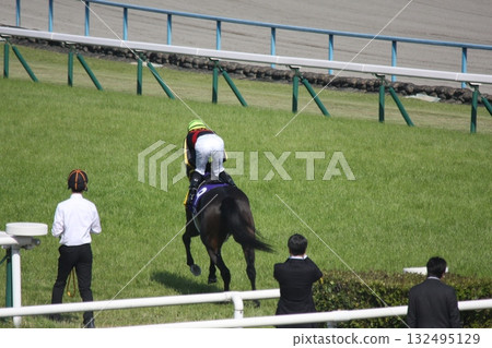 Horses and riders entering the main arena for the race Horses and riders entering the main arena for the race 132495129