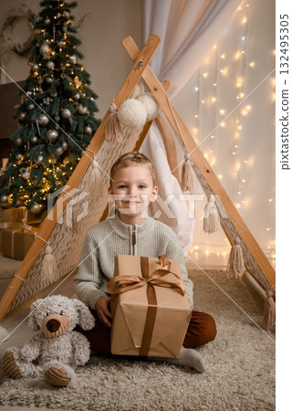Child with Gift Sitting by Christmas Tree and Teepee Child with Gift Sitting by Christmas Tree and Teepee 132495305