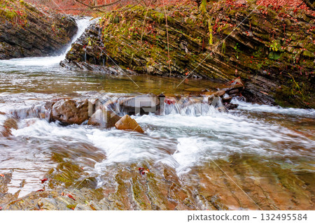 small waterfall on the turichka river in the forest near lumshory village of transcarpathia, ukraine. low angle view of the shore. beautiful autumnal scenery. popular travel destination. wide angle small waterfall on the turichka river in the forest near lumshory village of transcarpathia, ukraine. low angle view of the shore. beautiful autumnal scenery. popular travel destination. wide angle 132495584