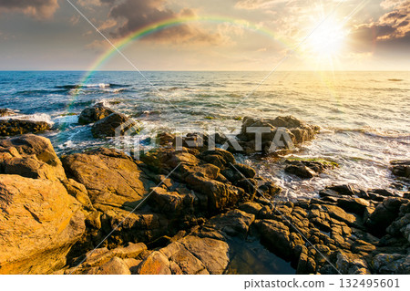 weekend on a rocky beach at the black sea under open blue sky at sunset. beautiful coastline in summer. seascape scenery with clouds above horizon in evening light. sunny weather weekend on a rocky beach at the black sea under open blue sky at sunset. beautiful coastline in summer. seascape scenery with clouds above horizon in evening light. sunny weather 132495601