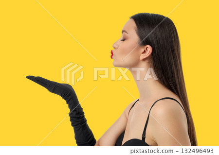 Woman in black top and gloves blowing a kiss Woman in black top and gloves blowing a kiss 132496493