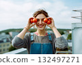 A woman is holding two tomatoes in her hands and smiling 132497271