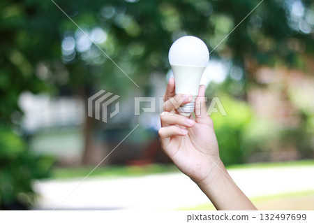 Human hand holding glowing light bulb symbolizing inspiration Human hand holding glowing light bulb symbolizing inspiration 132497699