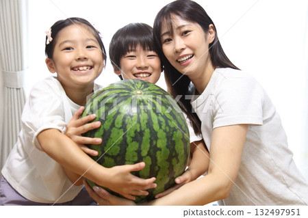 Parent and child holding a large watermelon Parent and child holding a large watermelon 132497951