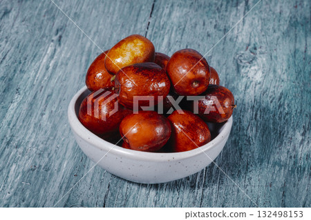 bowl filled with glossy jujube fruits 132498153