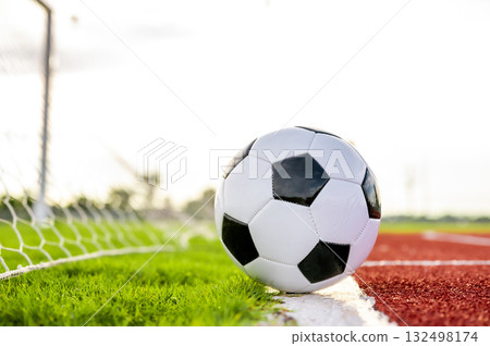 Footballs on the field and goal nets in a large stadium Footballs on the field and goal nets in a large stadium 132498174