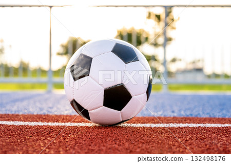 Footballs on the field and goal nets in a large stadium 132498176