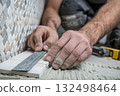 Worker installing ceramic floor tiles by hand 132498464