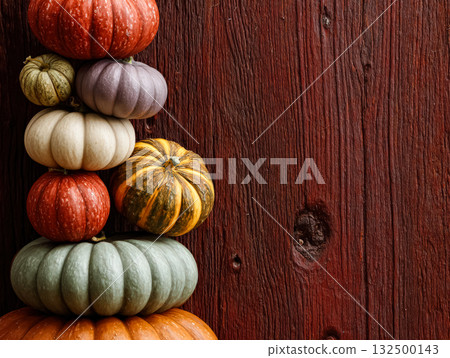Colorful stacked pumpkins on rustic wooden background showcasing autumn harvest beauty 132500143
