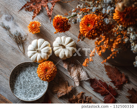 White pumpkins and vibrant flowers create a cozy autumn vibe with natural textures and warm colors White pumpkins and vibrant flowers create a cozy autumn vibe with natural textures and warm colors 132500310