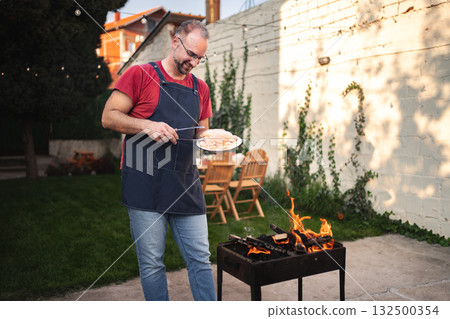 Grilling in the backyard: a joyous summer cookout experience Grilling in the backyard: a joyous summer cookout experience 132500354