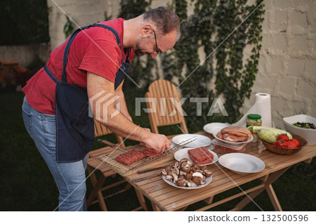 Preparing a delicious barbecue feast in a cozy backyard setting Preparing a delicious barbecue feast in a cozy backyard setting 132500596