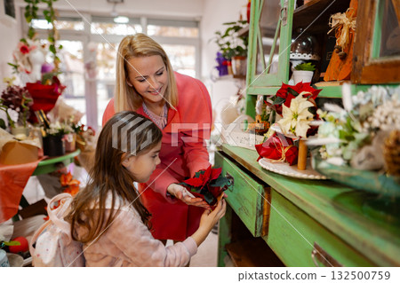 Joyful bonding moment between mother and daughter in a charming flower shop Joyful bonding moment between mother and daughter in a charming flower shop 132500759