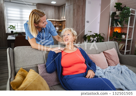 Caregiver supports elderly woman in cozy living room setting Caregiver supports elderly woman in cozy living room setting 132501505