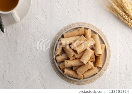 Khanom Thong Muan, crispy egg roll,Thai sweetmeat made of flour, coconut milk and egg in white bowl.Top view. 132501824