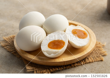 Salted eggs in wooden plate.a preserved food, traditionally made by curing duck or chicken eggs in brine.popular delicacy in many Asian cuisines. Salted eggs in wooden plate.a preserved food, traditionally made by curing duck or chicken eggs in brine.popular delicacy in many Asian cuisines. 132501826