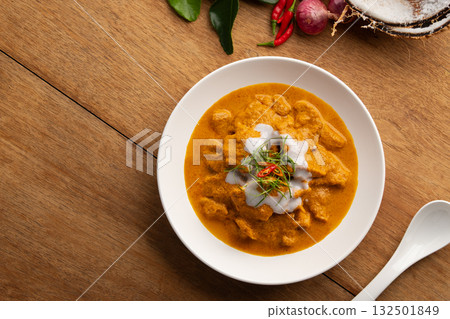 Panaeng Curry with pork.Sliced pork Meat in red curry paste and coconut milk,topping with coconut cream and Shredded kaffir lime leaves.Thai style food.Top view 132501849