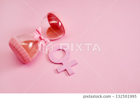 Hourglass with the female gender symbol. Women's health, menopause concept. Hourglass with the female gender symbol. Women's health, menopause concept. 132501995