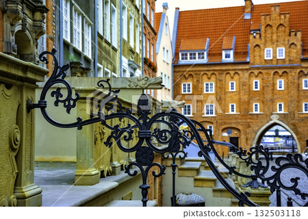 Captivating view of intricate wrought iron railings set against the historic red brick buildings in Gdansk Old Town. The architectural detail reflects the city's rich history 132503118