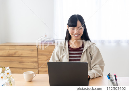 一名女大學生在家操作電腦 一名女大學生在家操作電腦 132503602