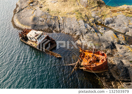 Wreckage of a sunken ship near rocky coastline in Norway, surrounded by cold northern waters and dramatic cliffs.  132503979